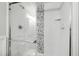 Modern bathroom shower with glass doors, pebble stone accent and clean white subway tile, offering a spa-like experience at 4906 Lakemont Dr, Raleigh, NC 27609