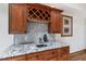 A finished wet bar area with granite countertops, hexagon tile backsplash, wine wrack and stained glass window at 4906 Lakemont Dr, Raleigh, NC 27609