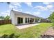 An exterior shot of the backyard with a patio, grass, and a wooden fence at 503 Kinship Ln, Apex, NC 27502