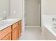 A bathroom with wood cabinets, a stone countertop, a sink, a toilet, and a shower/tub combo at 503 Kinship Ln, Apex, NC 27502