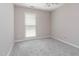 A bedroom with a window, gray carpet, and neutral-colored walls at 503 Kinship Ln, Apex, NC 27502