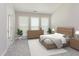 Bright bedroom featuring a wooden bed frame, dresser, and a sitting area with large windows for natural light at 503 Kinship Ln, Apex, NC 27502