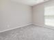 A bedroom with a window, gray carpet, neutral-colored walls, and a ceiling fan at 503 Kinship Ln, Apex, NC 27502