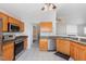 Functional kitchen featuring stainless steel appliances, wooden cabinets, and a spacious layout at 503 Kinship Ln, Apex, NC 27502