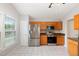 Well-lit kitchen with stainless steel refrigerator and oven adjacent to a window and wooden cabinets at 503 Kinship Ln, Apex, NC 27502