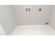 A laundry room with white walls and tile flooring; the wall has hookups for a washer and dryer at 503 Kinship Ln, Apex, NC 27502