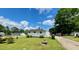 View of the rear of the property with a well-kept lawn and mature landscaping at 508 E Mcneill St, Lillington, NC 27546