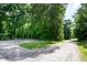 Gravel driveway leads to a wooded area providing ample space and access to the property at 5213 Tomahawk Trl, Raleigh, NC 27610