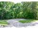 Gravel driveway leading to a wooded property with ample parking space and mature trees at 5213 Tomahawk Trl, Raleigh, NC 27610