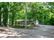 Secluded single-story home featuring mature trees and a gravel driveway at 5213 Tomahawk Trl, Raleigh, NC 27610