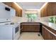 Well-lit kitchen showcasing white appliances and wood cabinets with a window view at 5213 Tomahawk Trl, Raleigh, NC 27610