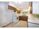 Functional kitchen with white appliances, wood cabinets, and a window overlooking the backyard at 5213 Tomahawk Trl, Raleigh, NC 27610