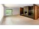 Living room with a brick fireplace, sliding doors to a patio, and ample natural light at 5213 Tomahawk Trl, Raleigh, NC 27610