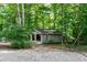 An open shed with windows situated on a gravel area in a wooded setting at 5213 Tomahawk Trl, Raleigh, NC 27610