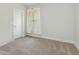 Neutral bedroom featuring soft carpet, door, and window with sheer curtains at 565 Joseph Alexander Dr, Fuquay Varina, NC 27526