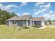 View of the home with blue siding, stone accents, landscaped front yard, and driveway to the garage at 565 Joseph Alexander Dr, Fuquay Varina, NC 27526