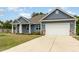 Charming home with blue siding, stone accents, a well-manicured lawn, and attached garage at 565 Joseph Alexander Dr, Fuquay Varina, NC 27526