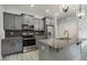 Modern kitchen featuring stainless steel appliances, gray cabinetry, and granite countertops at 565 Joseph Alexander Dr, Fuquay Varina, NC 27526