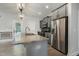 Open-concept kitchen with a large island, stainless steel refrigerator, and modern lighting fixtures at 565 Joseph Alexander Dr, Fuquay Varina, NC 27526