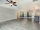 Open-concept living area with ceiling fan, gray flooring, and neutral wall paint at 565 Joseph Alexander Dr, Fuquay Varina, NC 27526