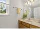 Bright bathroom featuring neutral-toned vanity with mirror and a large, natural-light window at 5704 Cholderton Ct, Raleigh, NC 27604