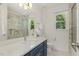Bright bathroom featuring a marble shower, blue vanity, and a sink, blending style and functionality at 5704 Cholderton Ct, Raleigh, NC 27604