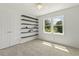 Bright bedroom with black shelving, ceiling fan, and a large window, offering ample storage and natural light at 5704 Cholderton Ct, Raleigh, NC 27604