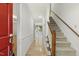 Bright foyer featuring wood floors, a staircase with carpeted steps and a red front door at 5704 Cholderton Ct, Raleigh, NC 27604