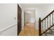 Inviting foyer with hardwood floors, a staircase with white spindles, and a dark wooden door at 5704 Cholderton Ct, Raleigh, NC 27604