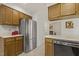 Spacious kitchen featuring stainless steel refrigerator and ample wood cabinets for plenty of storage at 5704 Cholderton Ct, Raleigh, NC 27604