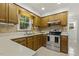 Classic kitchen features natural wood cabinets, stainless-steel appliances and view of the backyard at 5704 Cholderton Ct, Raleigh, NC 27604