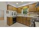Traditional kitchen featuring wood cabinets, neutral countertops, and a double basin sink under a window at 5704 Cholderton Ct, Raleigh, NC 27604