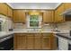 Kitchen with wood cabinets, stainless-steel appliances, and a window with a view of the outside at 5704 Cholderton Ct, Raleigh, NC 27604