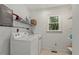 Functional laundry room with washer, dryer, shelving, and a window for natural light at 5704 Cholderton Ct, Raleigh, NC 27604
