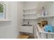 Practical utility sink with white shelving, great for storage, and next to natural light window at 5704 Cholderton Ct, Raleigh, NC 27604