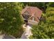 Aerial view of a beautiful home with a three-car garage, a long driveway, and mature trees in a private setting at 60 Morning Mist Dr, Garner, NC 27529