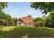 Spacious backyard with a well-manicured lawn, mature trees, and outdoor living spaces for relaxation and entertainment at 60 Morning Mist Dr, Garner, NC 27529