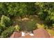 Large, verdant backyard featuring a patio and outdoor seating area with a fire pit, bench, and lush trees at 60 Morning Mist Dr, Garner, NC 27529
