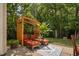 Inviting backyard patio with a pergola and comfortable seating area, surrounded by lush greenery and mature trees at 60 Morning Mist Dr, Garner, NC 27529