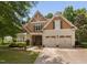 Charming two-story home featuring a manicured lawn, a two-car garage, and a combination of stone and wood facade at 60 Morning Mist Dr, Garner, NC 27529