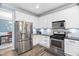 Bright kitchen featuring stainless steel appliances, white cabinets, and granite countertops at 60 Morning Mist Dr, Garner, NC 27529