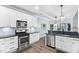 An open-concept kitchen featuring stainless appliances, white cabinets, and granite countertops at 60 Morning Mist Dr, Garner, NC 27529