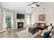 Vaulted ceiling living room featuring a fireplace, mounted TV, hardwood floors, and leather sofa at 60 Morning Mist Dr, Garner, NC 27529