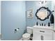 Cozy powder room with blue walls, a decorative mirror, and a white vanity at 60 Morning Mist Dr, Garner, NC 27529