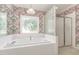 Bathroom featuring floral wallpaper, a stained glass window, a garden tub, and a glass enclosed shower at 600 Driftwood Dr, Gibsonville, NC 27249