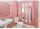 Powder room with pink wallpaper, pedestal sink, and unique vertical mirror accents at 600 Driftwood Dr, Gibsonville, NC 27249