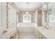 Bathroom with floral wallpaper, white vanity, soaking tub and stained glass window at 600 Driftwood Dr, Gibsonville, NC 27249