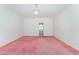 Large, open living room with soft pink carpeting and open access to bathroom at 600 Driftwood Dr, Gibsonville, NC 27249