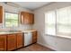 Well-lit kitchen featuring stainless steel dishwasher, sink, and wooden cabinets at 6540 English Oaks Dr, Raleigh, NC 27615