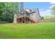 Lush backyard showcasing a two-story home with a screened-in porch and deck, backing up to mature trees at 68 Tanners Way, Clayton, NC 27527